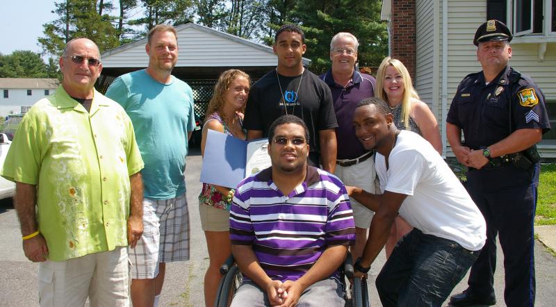Cedric Lopes, family, friends, and town officials pose in front of his West Wareham home after his welcoming reception. Back row from left to right: Selectmen Alan Slavin and Peter Teitelbaum, Mrs. Shelbi Lopes, Lance Corporal Cedric Lopes, Selectman Steve Holmes, Dolores Cleek, Sergeant Peter Flannery. Front row: Lopes' cousin Sidney Singletary and college friend Nathaniel Starling. BY RISHI SIDHU